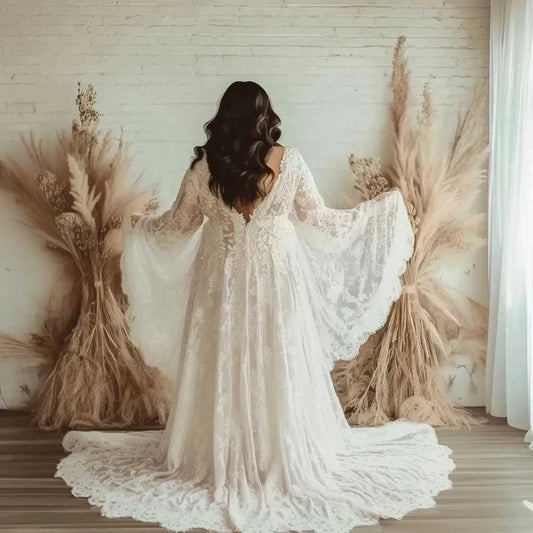 Ivory plus size wedding dress with low V-back, long lace bell sleeves, floral lace detailing and flowing lace-trimmed train