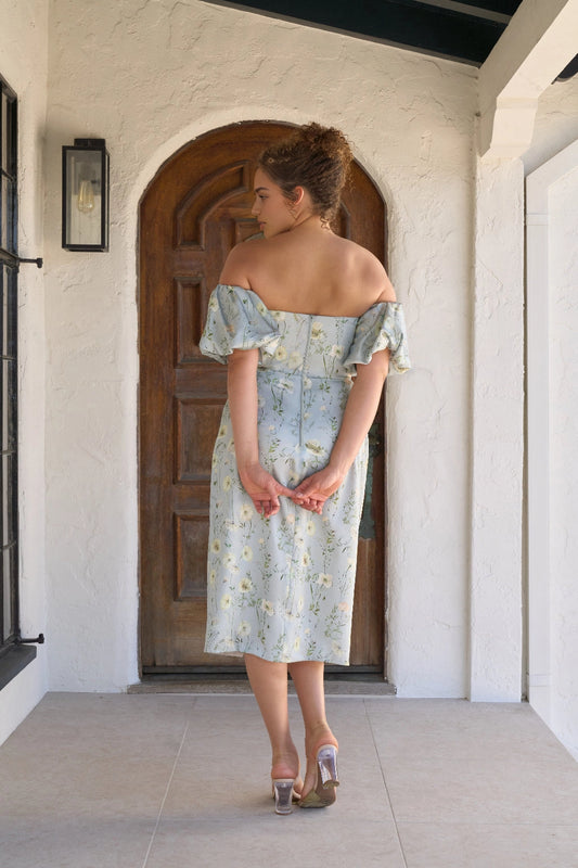 Back view of light blue floral plus size wedding guest dress with off shoulder puff sleeves, straight back neckline and center zipper by roselledress