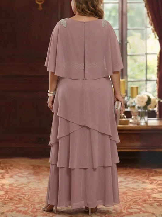 Back view of plus size dusty pink mother of the bride dress featuring cape overlay, layered skirt and center zipper closure.