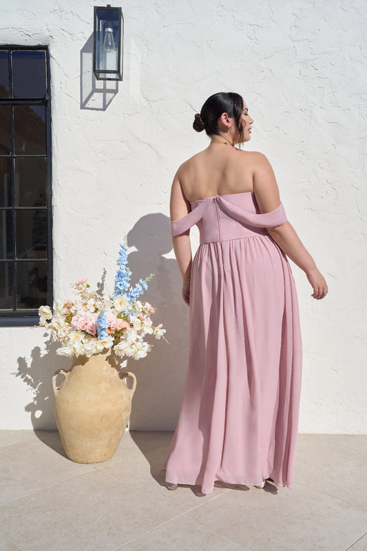 Back view of plus size dusty rose bridesmaid dress with off-shoulder sleeves, straight back, center zipper and flowing A-line skirt.