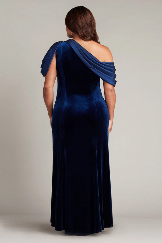 Back view of royal blue plus size velvet wedding guest dress featuring asymmetric shoulder draping and a flowing floor-length skirt by roselledress