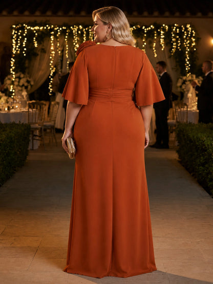 Burnt orange plus size evening gown back view, round neck, center back zipper, flutter sleeves and trumpet floor length skirt
