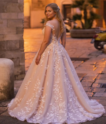 Curvy bride wearing Roselledress illusion back plus‑size lace wedding dress shimmer tulle chapel train