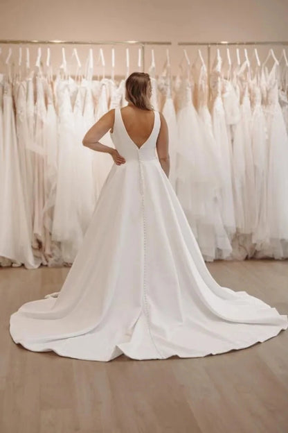 Curvy bride wearing Roselledress v‑back plus‑size satin wedding dress pearl button back chapel train