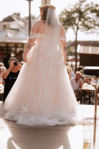 Curvy bride wearing Roselledress open‑back plus‑size a‑line lace wedding dress outdoor back view