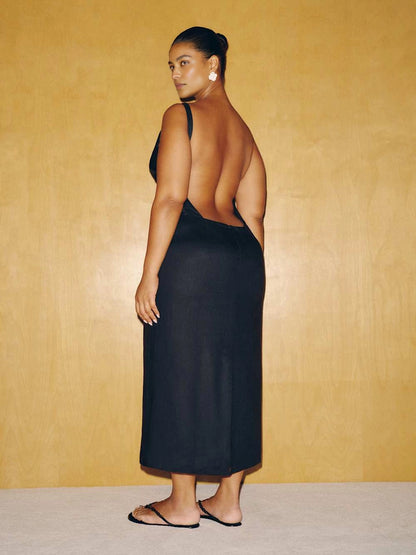 roselledress black plus‑size midi formal dress dramatic deep open back single thin strap column silhouette modern wedding guest dress back view