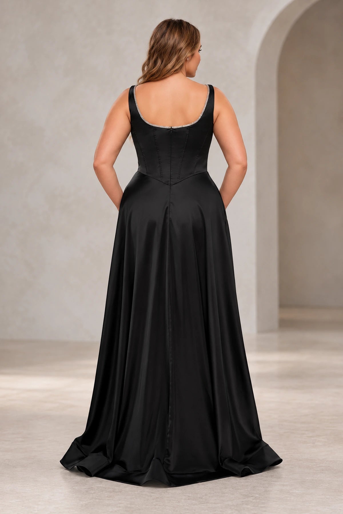 Back view of a black satin prom dress with a sparkling scoop neckline, center zipper, V-shaped waist and subtle sweep train.