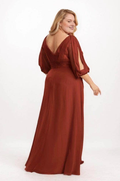 Back view of a Roselledress rust plus size bridesmaid dress with a V-shaped back, pleated waist, split sleeves and a flowing floor-length skirt.