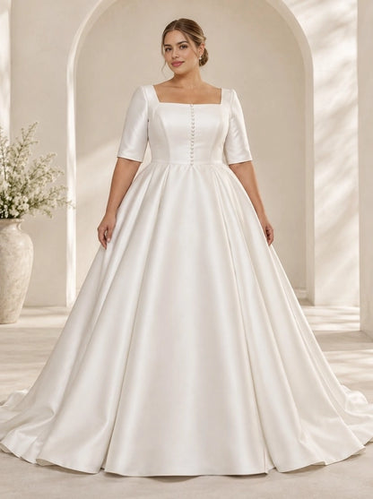 Ivory plus size satin wedding dress with square neckline, short sleeves, decorative front buttons and full A-line skirt.