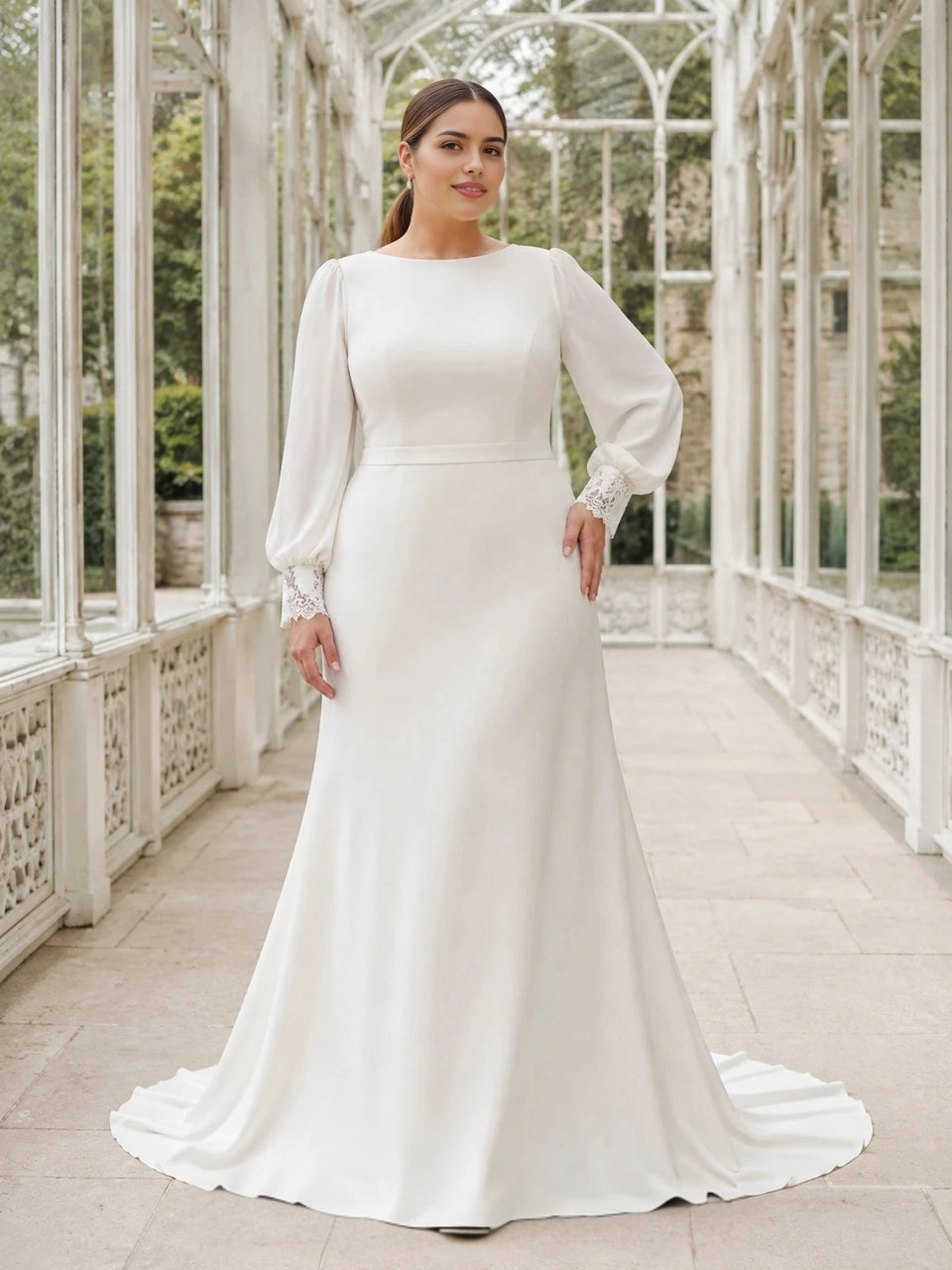 Ivory plus size wedding dress with bateau neckline, long bishop sleeves, lace cuffs and a flowing fit-and-flare skirt.
