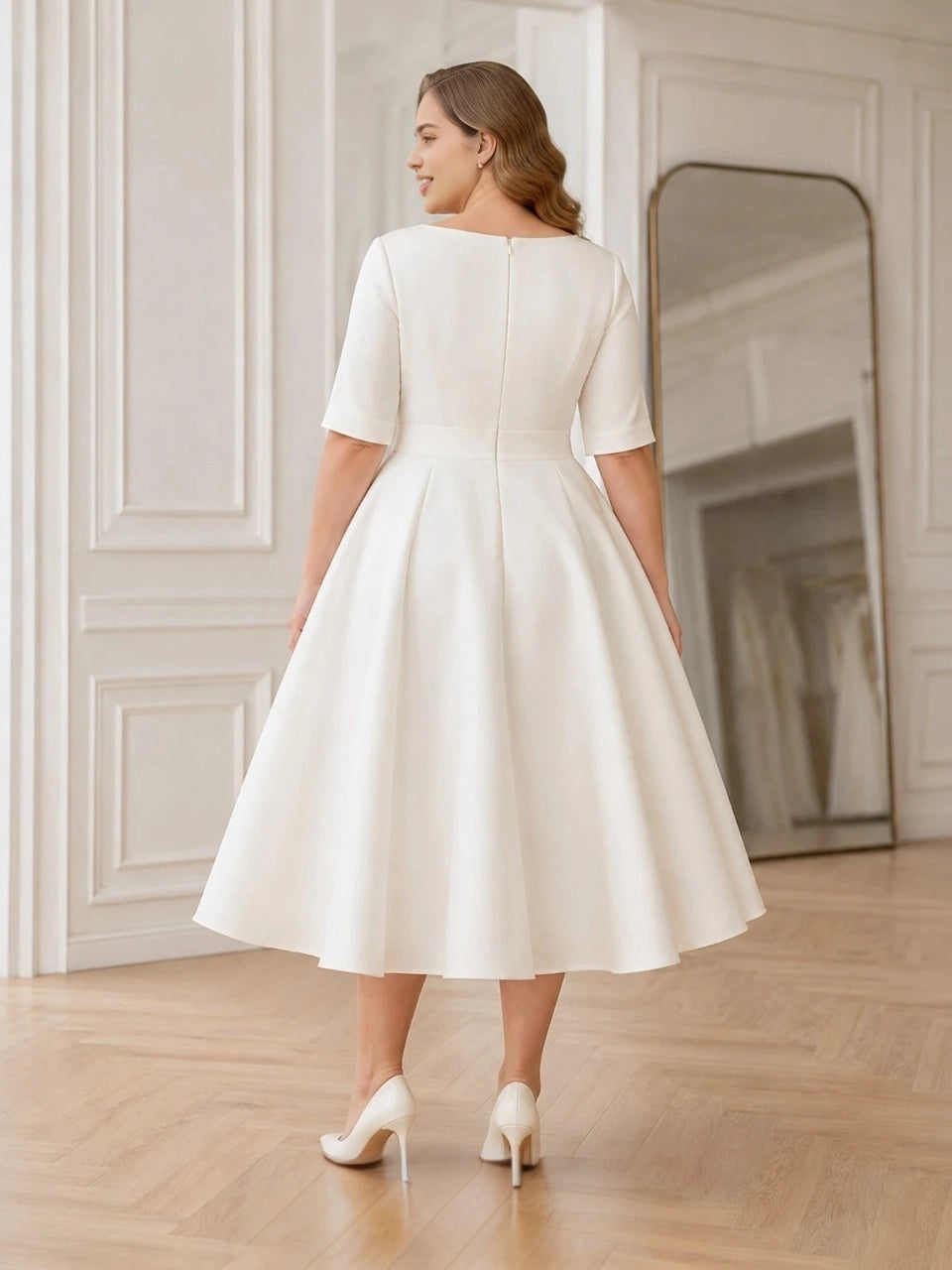 Back view of an ivory plus size midi wedding dress with short sleeves, closed back and center zipper.