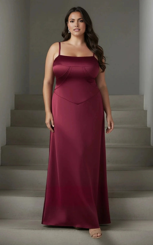 Burgundy plus size wedding guest dress with square neckline, spaghetti straps, structured bust seams, basque waist and floor-length satin-look skirt