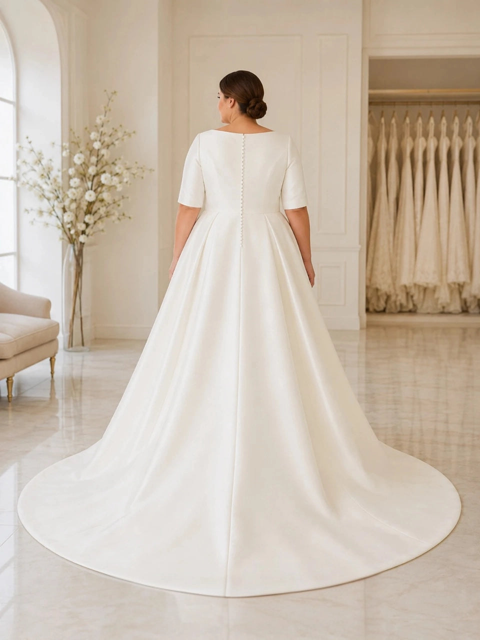Back view of ivory plus size wedding dress with square back, covered button details, short sleeves and a sweeping satin skirt.