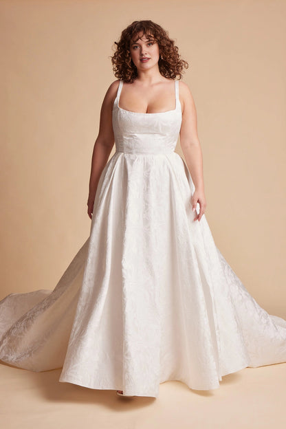 Ivory plus size A-line wedding dress with square neckline, shoulder straps, floral textured bodice and flowing floor-length skirt