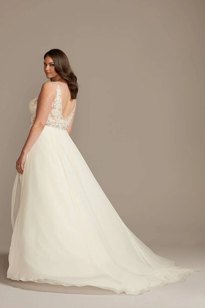 Ivory plus size lace wedding dress with deep V-back, sheer floral lace detailing, defined waist and flowing A-line skirt with sweep train