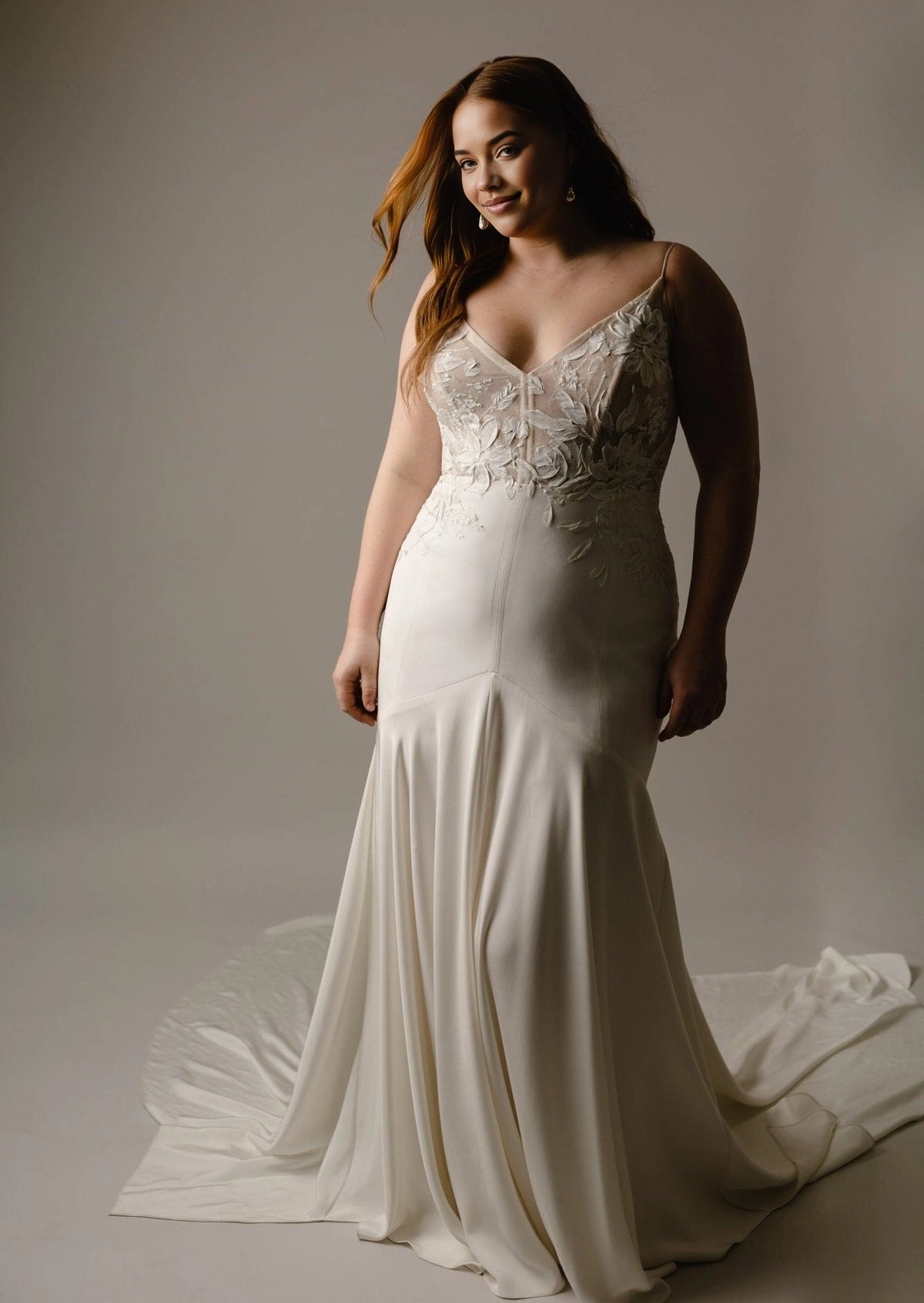 Ivory plus size mermaid wedding dress with floral lace V-neck bodice, spaghetti straps, fitted silhouette and flowing floor-length skirt