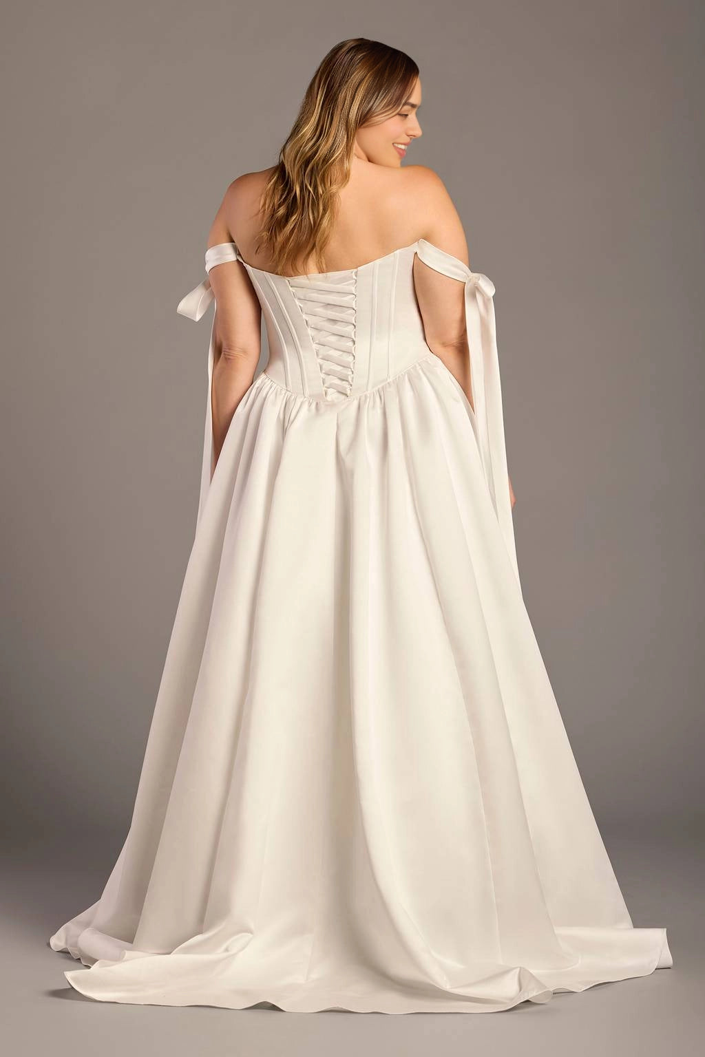 Ivory plus size wedding dress with lace-up corset back, crisscross ribbon closure, off-shoulder bow straps and flowing satin-look skirt