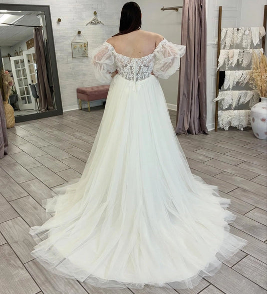 Ivory plus size wedding dress with sheer floral lace zipper back, off-shoulder puff sleeves and flowing layered tulle train