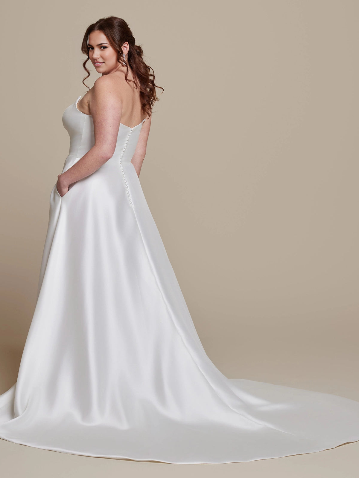 Ivory plus size strapless wedding dress with low V-shaped back, covered button details, flowing A-line skirt and elegant sweep train