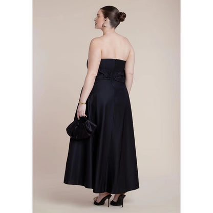 Back view of plus size black wedding guest dress featuring strapless back, zipper closure and elegant bow waist detail.