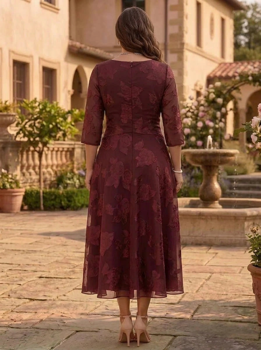 Back view of plus size burgundy mother of the bride dress featuring floral textured fabric, three quarter sleeves and center zipper closure.