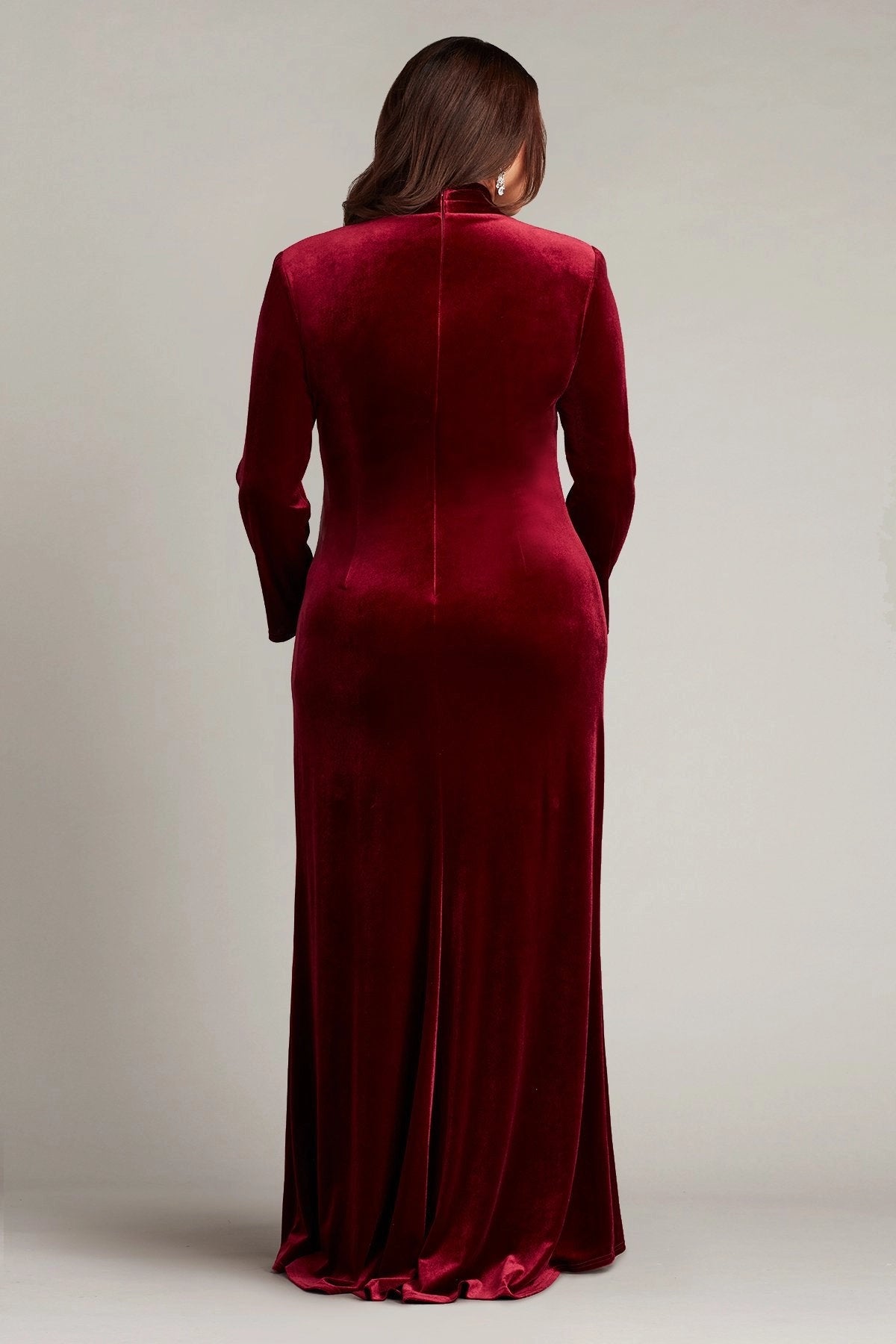 Back view of burgundy plus size velvet wedding guest dress featuring a high closed back, long sleeves and floor-length sheath skirt by roselledress