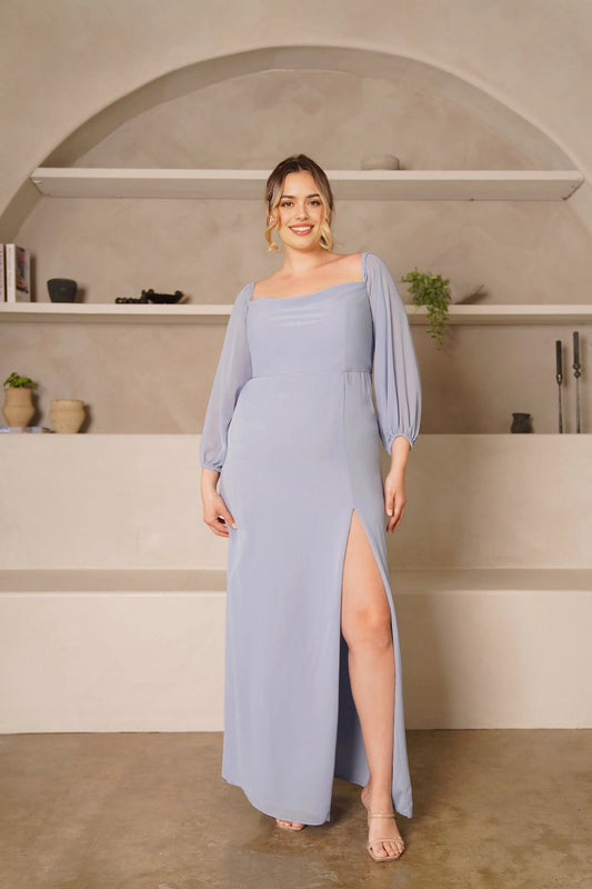 Plus size dusty blue bridesmaid dress with draped square neckline, three-quarter balloon sleeves, defined waist and floor-length sheath skirt with front slit.