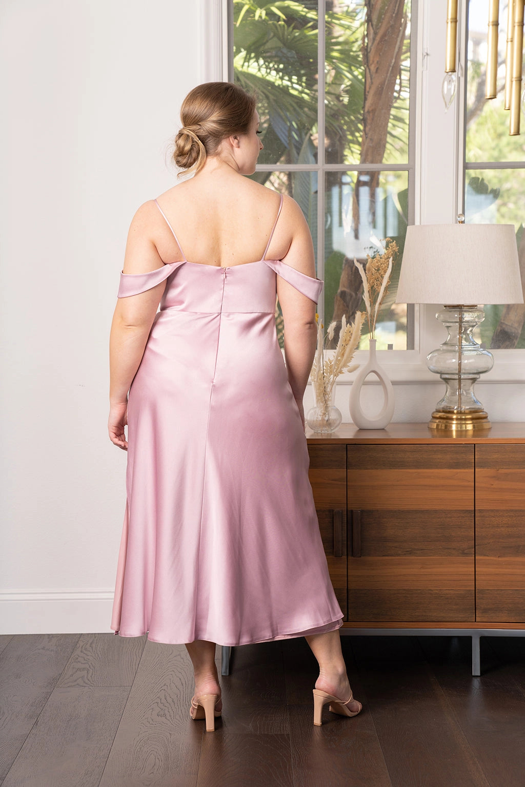 Back view of dusty rose plus size bridesmaid dress featuring off shoulder sleeves, spaghetti straps, center zipper and flowing midi skirt by roselledress