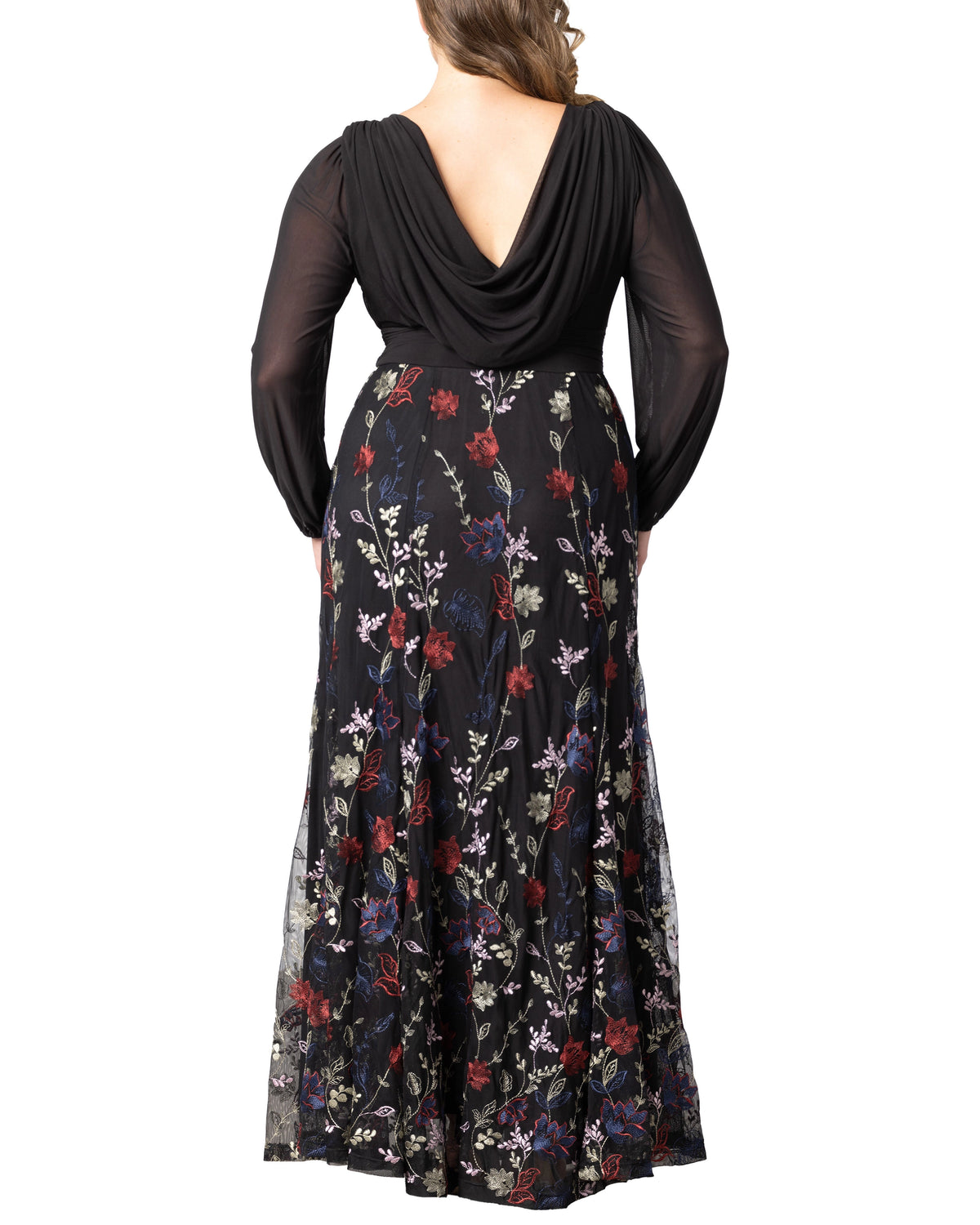 Back view of plus size black floral jacquard wedding guest dress featuring draped back, long sleeves and embroidered flowing skirt.
