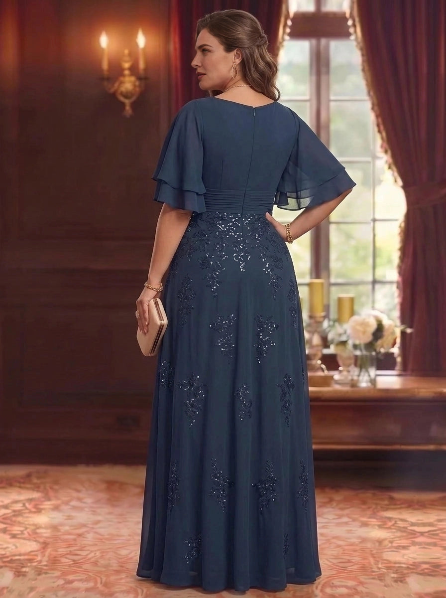 Back view of plus size navy blue mother of the bride dress featuring flutter sleeves, embroidered skirt and center zipper closure.