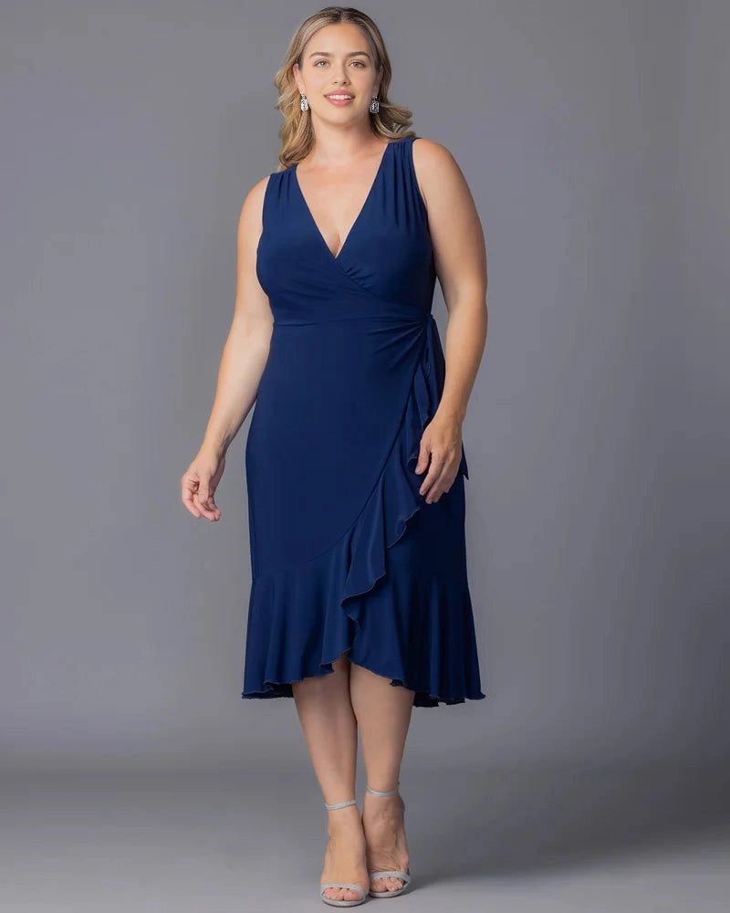 Navy blue plus size wedding guest dress with wrap V-neckline, sleeveless design, side waist draping and asymmetric ruffle midi hem by roselledress