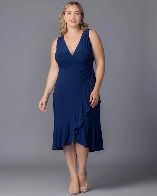 Navy blue plus size wedding guest dress with wrap V-neckline, sleeveless design, side waist draping and asymmetric ruffle midi hem by roselledress
