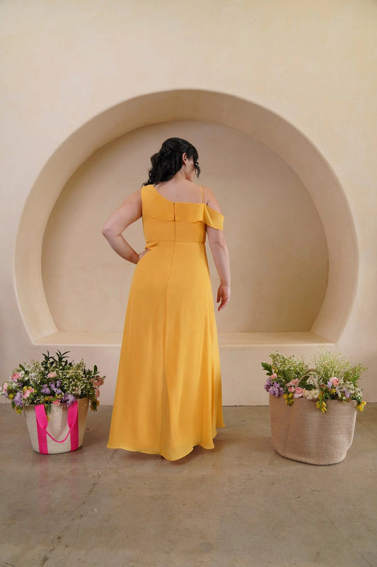 Back view of golden yellow plus size bridesmaid dress featuring an asymmetric neckline, concealed zipper and flowing A-line skirt