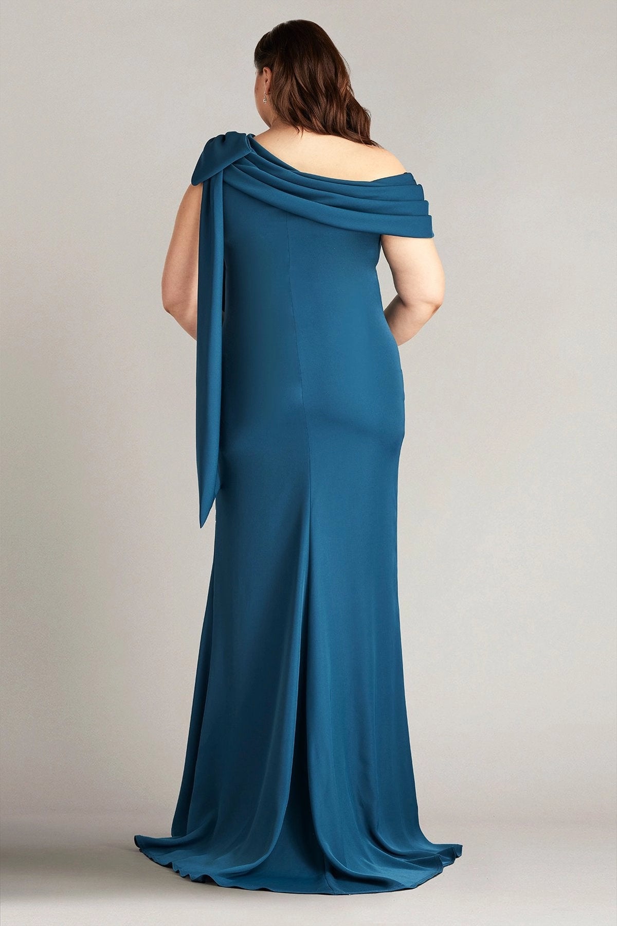 Back view of teal blue plus size wedding guest dress with draped asymmetric neckline, flowing shoulder sash and mermaid silhouette by roselledress
