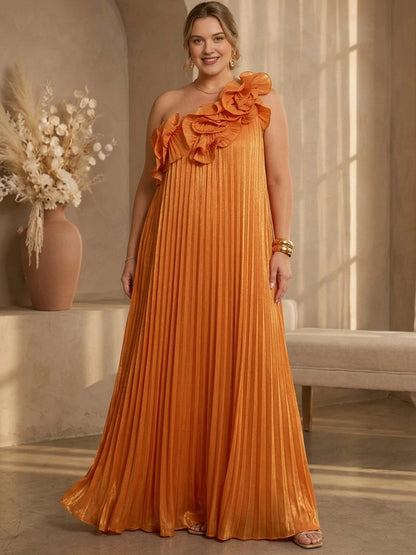 Plus size orange metallic pleated one-shoulder wedding guest dress with 3D ruffle flower detail and floor length flowing skirt, front view
