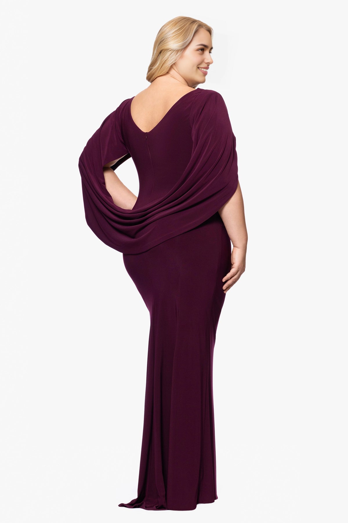 Back view of plum purple plus size wedding guest dress featuring V-back neckline, draped cape shawl and center zipper by roselledress