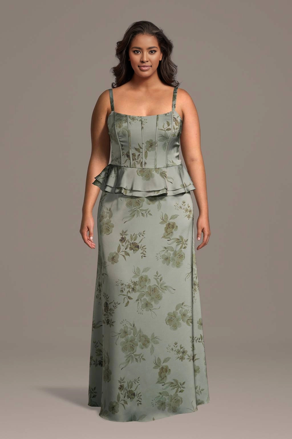 Plus size sage green floral satin wedding guest dress with square neck, thin straps, corset bodice, peplum waist and long slip skirt, front view
