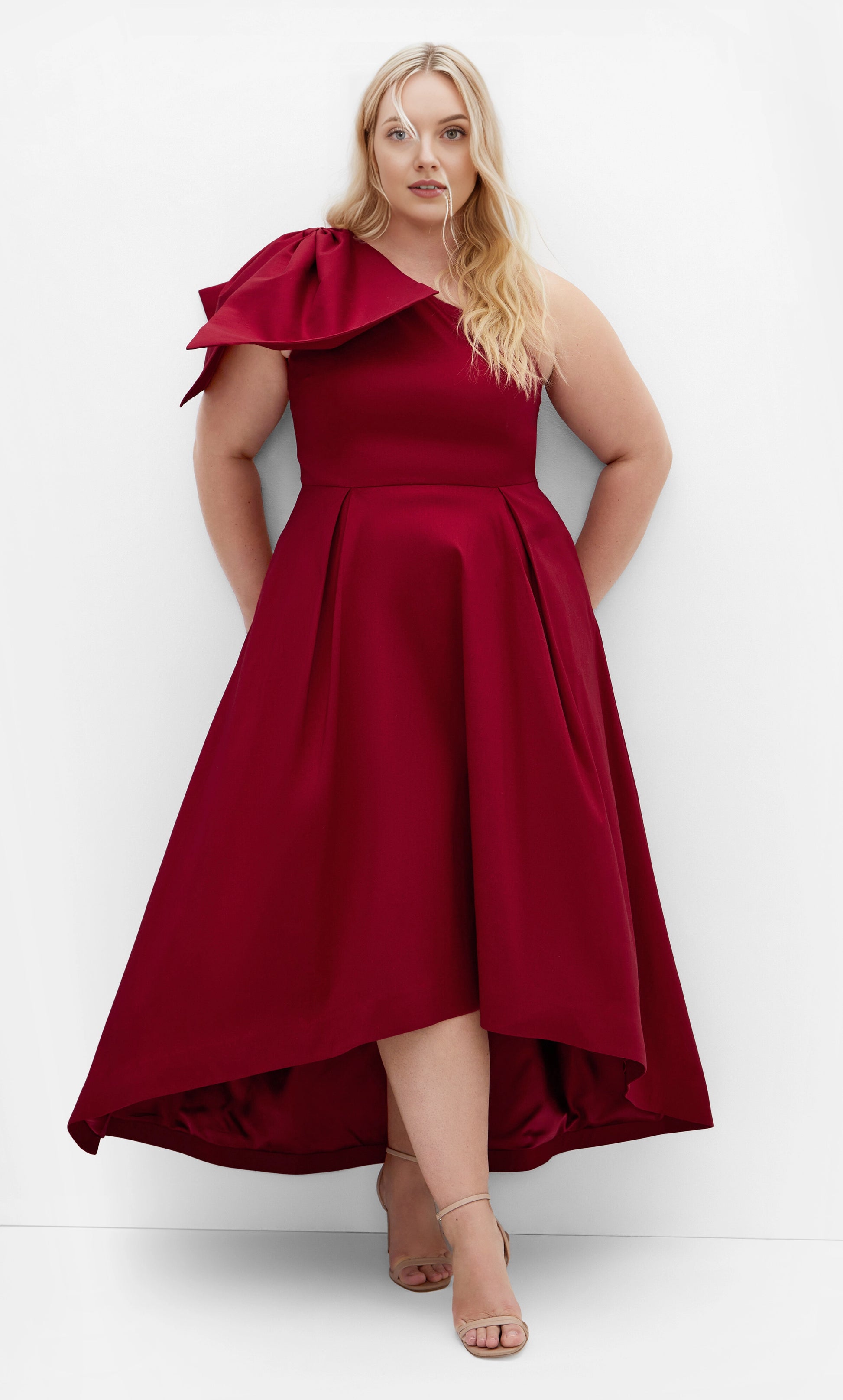 RoselleDress burgundy plus size A‑line wedding guest dress one‑shoulder large bow detail high‑low hem side pockets midi‑maxi front view