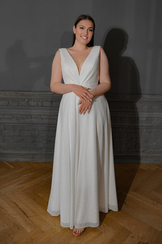 White plus size A-line wedding dress with plunging V-neckline, sleeveless pleated glitter bodice, defined waist and flowing floor-length skirt
