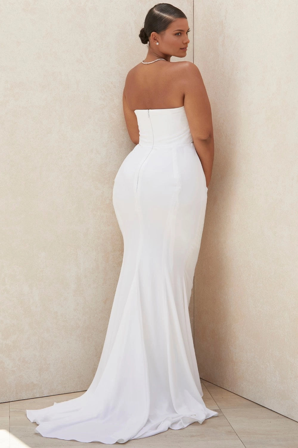 White plus size strapless wedding dress with straight back neckline, center zipper closure, fitted mermaid silhouette and sweeping train