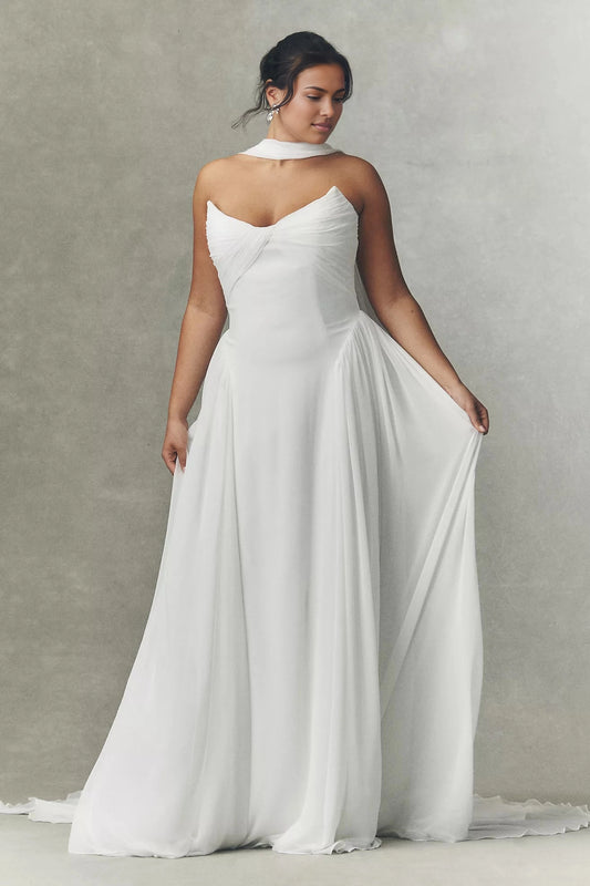 White plus size A-line wedding dress with strapless sweetheart neckline, draped bodice, scarf neck detail and flowing chiffon-look skirt
